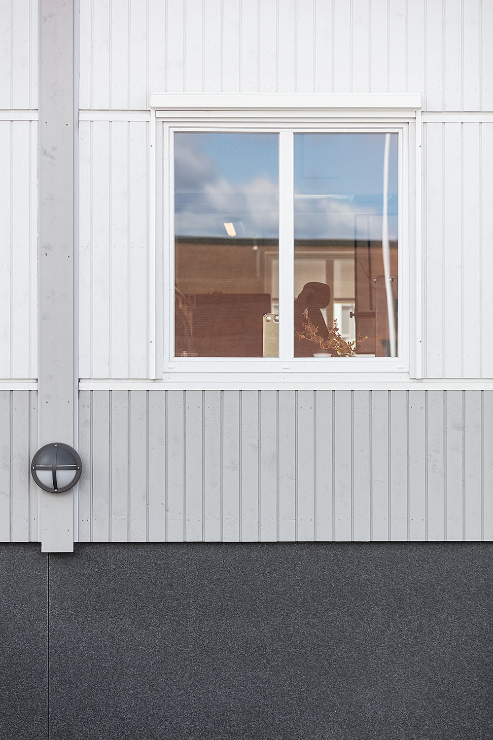 Detalj av fasad med fönster och utomhusbelysning i ljusgrå kontorslösning, där modulerna kommer från Expandia.