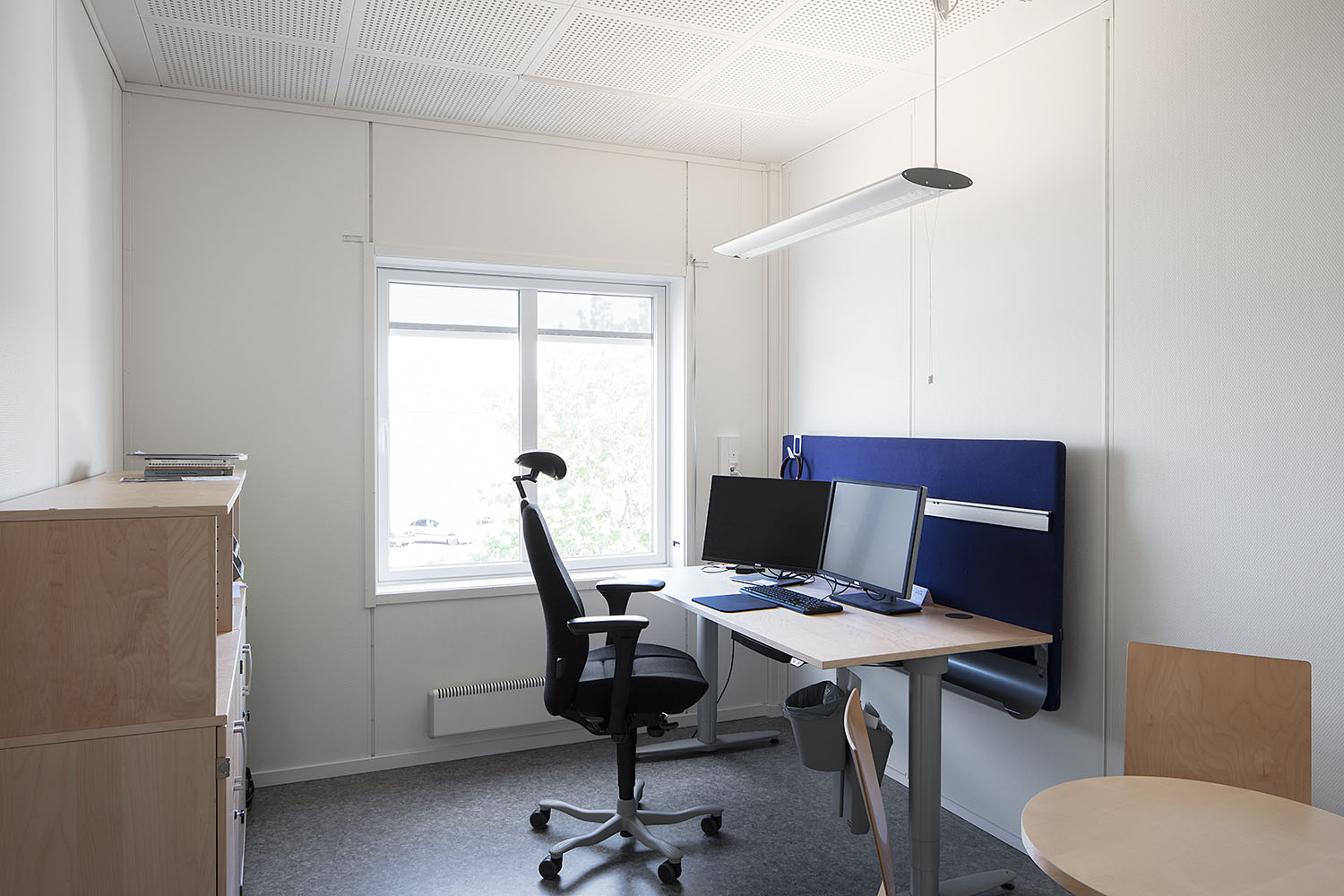 Ljust och funktionellt kontorsrum med skrivbord, arbetsstol och fönster som släpper in dagsljus, i moduler från Expandia.