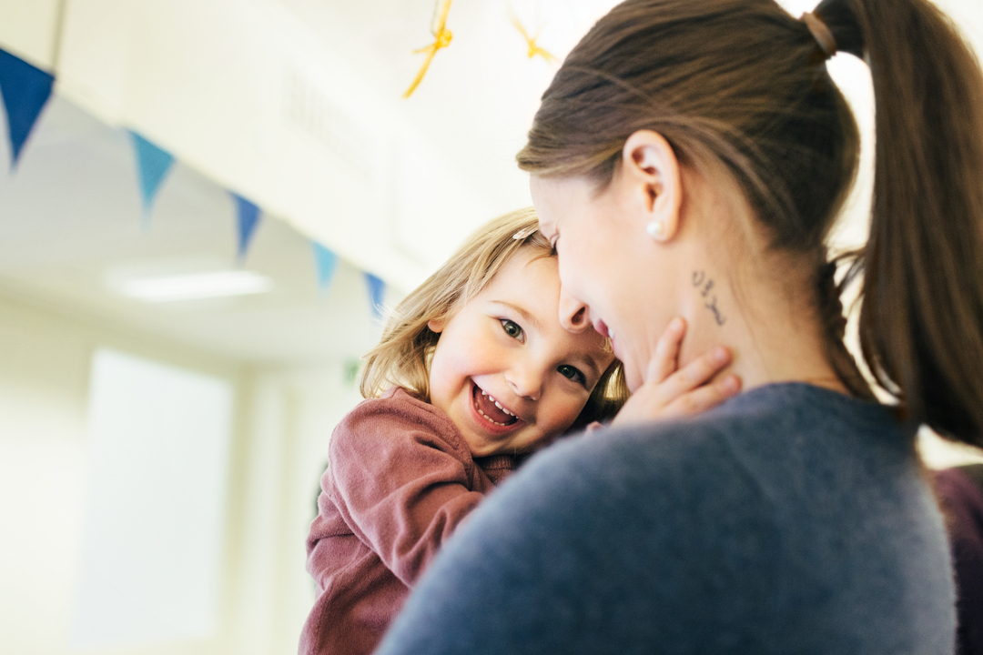 Barn og ansatt i en trygg og omsorgsfull situasjon innendørs i barnehage, i lyse og moderne lokaler fra Expandia.